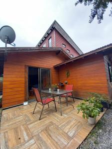 a patio with a table and chairs and a house at Ruka Experience in Pucón