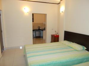 a bedroom with a bed and a kitchen in the background at Bedroom with Pantry in Mount Lavinia