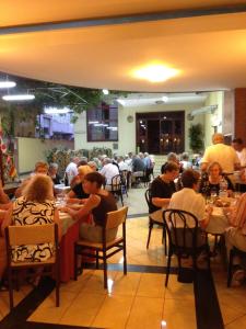 a group of people sitting at tables in a restaurant at Hotel Ristorante Amitrano in Pompei