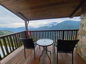 a table and two chairs on a balcony with mountains at Top Cloud Villa in Renai