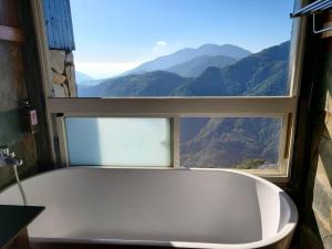 a bath tub in a bathroom with a window at Top Cloud Villa in Renai