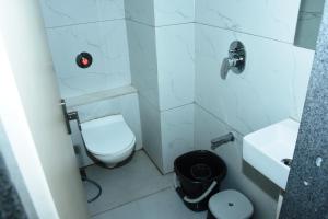 a small bathroom with a toilet and a sink at Hotel J K and Restaurant Couple Friendly in Morbi +7 photos