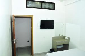 a room with a bed and a tv on the wall at Hotel J K and Restaurant Couple Friendly in Morbi