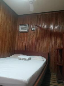 a bedroom with a bed with a air conditioner on the wall at Naramalan Inn in San Vicente