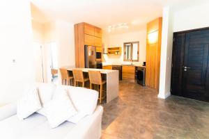 a living room with a white couch and a kitchen at Salty Breeze in Flic-en-Flac