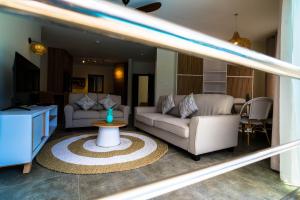 a living room with two couches and a table at Salty Breeze in Flic-en-Flac