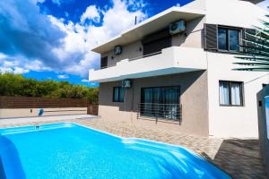 a villa with a swimming pool in front of a house at Salty Breeze in Flic-en-Flac