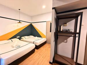 a hotel room with two beds and a shelf at Seeds Hotel Puchong Koi in Puchong