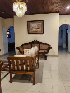 a living room with a couch and a chandelier at Heritage Bungalow Hikkaduwa in Hikkaduwa