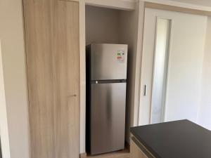 una nevera de acero inoxidable en una cocina junto a una puerta en Departamento Viña del Mar, en Viña del Mar