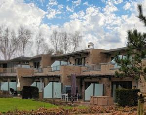 un grand bâtiment en briques avec des arbres en arrière-plan dans l'établissement Residenz-Am-Wald-Nr-2-0, à Sankt Peter-Ording