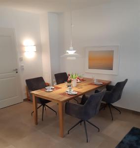 une salle à manger avec une table et des chaises en bois dans l'établissement Residenz-Am-Wald-Nr-2-0, à Sankt Peter-Ording