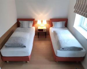 deux lits dans une chambre avec une table et deux lampes dans l'établissement Residenz-Am-Wald-Nr-2-0, à Sankt Peter-Ording 19 autres photos