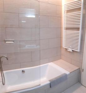 une baignoire blanche dans une salle de bains avec fenêtre dans l'établissement Residenz-Am-Wald-Nr-2-0, à Sankt Peter-Ording