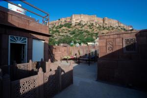 a building with a fence with a mountain in the background at Aakash Heritage Haveli in Jodhpur