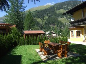 stół i krzesła na dziedzińcu z górą w obiekcie Appartement Schneeglöckchen w mieście Bad Gastein