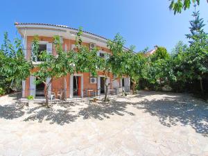 una casa de naranjos con árboles delante de ella en Emilia Apartments, en Trapezaki