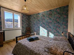 ein Schlafzimmer mit einem Bett mit Blumentapete in der Unterkunft Gîte spacieux pour 10 pers. avec grand jardin à Tence - FR-1-582-528 in Tence