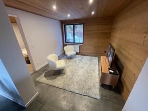 un soggiorno con 2 sedie e una TV di Chalet rénové pour 12 pers. à Super Besse - FR-1-814-89 a Besse-et-Saint-Anastaise