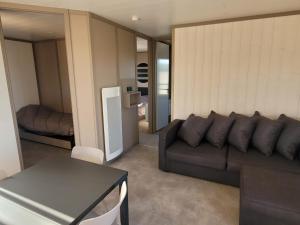 a living room with a couch and a table at Chalet 3 chambres avec terrasse calme à Saint-Romain-de-Benet - FR-1-783-48 in Saint-Romain-de-Benet