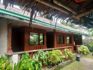 a house with a bunch of plants in front of it at Naramalan Inn in San Vicente
