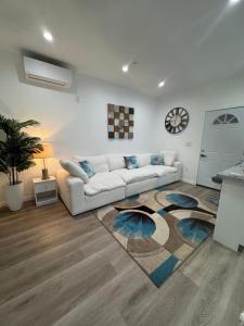 a living room with a white couch and a rug at Luxury mini house in Hughes-Canoga Park Heliport