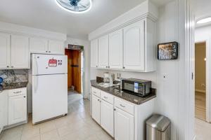 a kitchen with white cabinets and a white refrigerator at 15 Mi to Dtwn Detroit Cozy Family Home with Yard! in Detroit