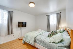 a bedroom with a bed and a flat screen tv at 15 Mi to Dtwn Detroit Cozy Family Home with Yard! in Detroit