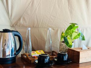 a table with a coffee pot and vases on it at De'Ra Hills Camp Kintamani in Kintamani