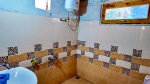 a bathroom with a sink and a window at Rustic Mud House Jibhi in Jibhi