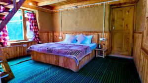 a bedroom with a bed in a wooden room at Rustic Mud House Jibhi in Jibhi