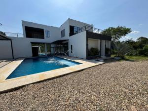 a house with a swimming pool in front of it at Quinta Leal in Melgar