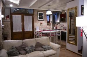 ein Wohnzimmer mit einem Sofa und einer Küche in der Unterkunft Antica Dimora Julia in Spello