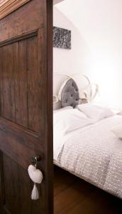 Schlafzimmer mit einem Bett und einer Holztür in der Unterkunft Antica Dimora Julia in Spello