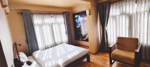 una camera da letto con un letto, una sedia e una finestra di Sabila Boutique Hotel a Kathmandu