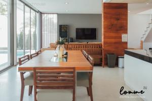 a dining room with a table and a couch at lomme Private Beach House in Cha Am