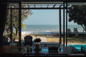 a view of the beach from a restaurant with a table and chairs at lomme Private Beach House in Cha Am