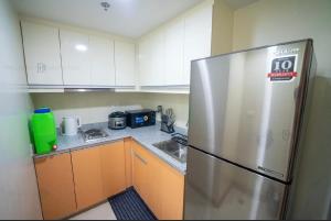 a kitchen with a stainless steel refrigerator and cabinets at The Palladium Megaworld in Iloilo City +7 photos