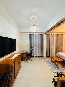 a room with a television and a bed and a desk at The Palladium Megaworld in Iloilo City
