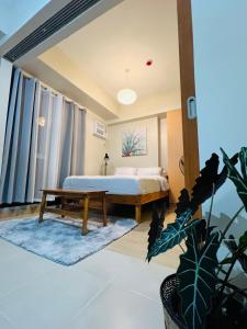 a bedroom with a bed and a table at The Palladium Megaworld in Iloilo City
