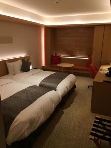 a hotel room with two beds and a table at ANA Crowne Plaza Hotel Kyoto by IHG in Kyoto