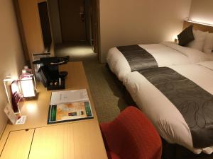 a hotel room with two beds and a book on a table at ANA Crowne Plaza Hotel Kyoto by IHG in Kyoto