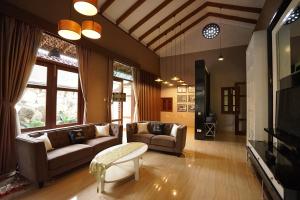 un soggiorno con due divani e una TV di Patria Villa With Private Pool Near Hyatt a Beran-kidul