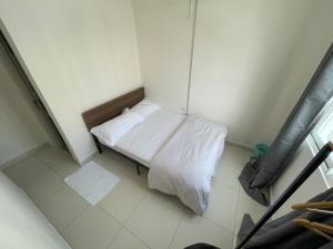 a small room with a bed with white sheets at Clove Beach Hulhumale in Male City