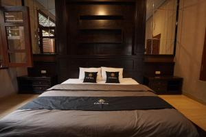 una camera da letto con un letto grande con due cuscini di Patria Villa With Private Pool Near Hyatt a Beran-kidul Altre 12 foto