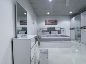 Un dormitorio blanco con una cama y un espejo. en Old Muscat- Sidab, en Mascate 19 fotos más