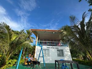 two people and two dogs on a slide in front of a house at Jlb resort and tours,Guest House in Valdez