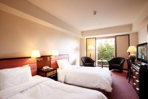 a hotel room with two beds and a television at ANA Crowne Plaza Hotel Kyoto by IHG in Kyoto