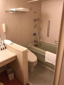 a bathroom with a toilet and a tub and a sink at ANA Crowne Plaza Hotel Kyoto by IHG in Kyoto