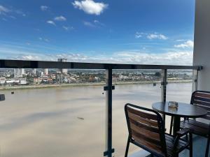 a balcony with a table and chairs and a view of a river at X One Hotel in Phnom Penh